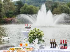 Hochzeitsapéro aufgebaut auf Tischen vor einem Springbrunnen auf Wasser